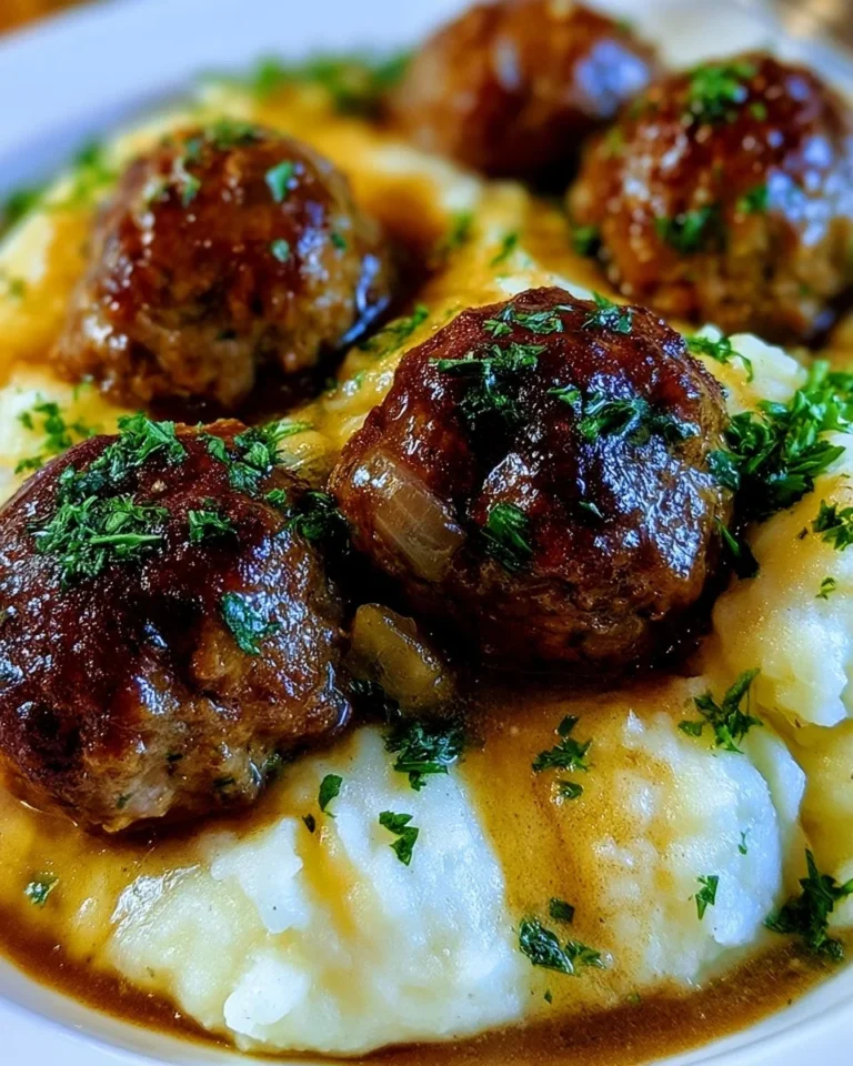 Salisbury steak meatballs with garlic herb mashed potatoes served on a plate